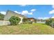 Spacious backyard with green grass, landscaping, and a covered back porch at 2025 Viewpoint Landings Rd, Lakeland, FL 33810