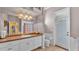 Bathroom features a well-lit vanity with sink and white cabinets, complemented by a toilet and exterior door at 2025 Viewpoint Landings Rd, Lakeland, FL 33810