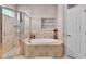 Beautiful bathroom with glass shower, garden tub, and decoratively tiled walls with glass shelf inserts at 2025 Viewpoint Landings Rd, Lakeland, FL 33810