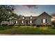 Inviting home featuring a green lawn, mature trees, and a classic front porch with porch swing at 2025 Viewpoint Landings Rd, Lakeland, FL 33810