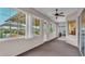 Sunroom featuring walls of bright windows, carpet flooring, and a ceiling fan, providing ample natural light at 2025 Viewpoint Landings Rd, Lakeland, FL 33810