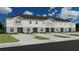 Three-story townhome exterior with gray siding, a brown roof, and individual parking spots at 218 Turtle Bay Ave, Winter Haven, FL 33881