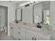 Bathroom with dual sinks, modern black fixtures, white cabinets, and marble tile flooring at 2255 Couples Dr, Lakeland, FL 33813