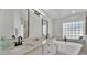 Bathroom featuring a standalone tub, dual sinks, glass block window, and modern fixtures at 2255 Couples Dr, Lakeland, FL 33813