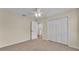 A well-lit bedroom with neutral walls, carpet flooring, ceiling fan, closet and an ensuite bathroom at 2255 Couples Dr, Lakeland, FL 33813