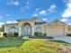 Charming home exterior with landscaped yard, double door entry, and attached two-car garage at 2255 Couples Dr, Lakeland, FL 33813