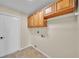 Functional laundry area featuring tile flooring, overhead cabinetry, and in-wall hookups at 2255 Couples Dr, Lakeland, FL 33813