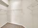 Spacious walk-in closet featuring carpet flooring and multiple white wire shelving units for storage at 2255 Couples Dr, Lakeland, FL 33813