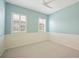Empty bedroom with carpet, light blue walls, two windows, and a ceiling fan at 2425 Laurel Glen Dr, Lakeland, FL 33803