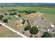 Wide-angle aerial showing the home, landscaping, and surrounding acreage with mature trees and other outbuildings at 246 Quail Run, Frostproof, FL 33843