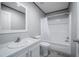 This bathroom features a white tub with shower, white toilet and sink and neutral wall and floor coverings at 246 Quail Run, Frostproof, FL 33843