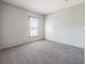 Bright bedroom featuring neutral carpet, trim, and one bright window at 246 Quail Run, Frostproof, FL 33843