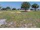 Neutral colored single-story home with black shutters surrounded by a large lawn at 246 Quail Run, Frostproof, FL 33843