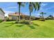 Expansive backyard with lush green grass, mature landscaping, and a covered patio at 2464 Laurel Glen Dr, Lakeland, FL 33803