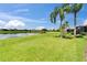 Backyard view of lake with lush landscaping and blue sky at 2464 Laurel Glen Dr, Lakeland, FL 33803