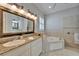 Luxurious bathroom featuring a soaking tub, granite countertops, and vanity with ornate mirror at 2464 Laurel Glen Dr, Lakeland, FL 33803