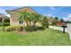 Landscaped front yard with lush grass, palm trees, and well-maintained exterior at 2464 Laurel Glen Dr, Lakeland, FL 33803