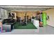 A well-equipped home garage gym features weights, squat rack, and organization for fitness enthusiasts at 2464 Laurel Glen Dr, Lakeland, FL 33803