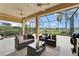 Screened lanai with comfortable seating, ceiling fans, and view of the serene lake at 2464 Laurel Glen Dr, Lakeland, FL 33803