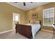 This cozy bedroom has a wood-framed bed, neutral carpet, and a window that lets in natural light at 2731 Coventry Ave, Lakeland, FL 33803