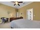 Bedroom with a ceiling fan and neutral carpet features a wood-framed bed, side table, and decorative chair at 2731 Coventry Ave, Lakeland, FL 33803