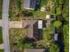 Wide aerial view of home featuring lush lawns, mature landscaping, and a small stream running behind the home at 2757 Pine Acres Dr, Lake Wales, FL 33898