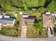 Wide aerial shot of a residential neighborhood with mature trees, well-maintained lawns and a stream at 2757 Pine Acres Dr, Lake Wales, FL 33898
