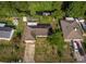Wide aerial shot of the home and neighborhood with mature trees, grassy lawns, and a small neighborhood stream at 2757 Pine Acres Dr, Lake Wales, FL 33898