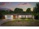 Charming single-story home featuring a well-maintained lawn and attached garage, set against a colorful twilight sky at 2757 Pine Acres Dr, Lake Wales, FL 33898