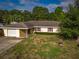 Quaint single story home featuring a side entry garage and a well-maintained lawn with mature landscaping at 2757 Pine Acres Dr, Lake Wales, FL 33898