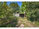 Dilapidated backyard shed with lattice and corrugated metal, nestled among overgrown foliage and trees at 2757 Pine Acres Dr, Lake Wales, FL 33898