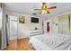 Bright bedroom featuring hardwood floors, ceiling fan, tv, and white dresser at 2810 Gary Ln, Lakeland, FL 33812