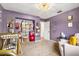 Bedroom features purple walls, decor, changing table, and open closet at 2810 Gary Ln, Lakeland, FL 33812