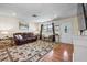 Comfortable living area with hardwood floors, a leather couch, bench seating, and a view of the front entrance at 2810 Gary Ln, Lakeland, FL 33812