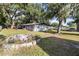 Backyard with a brick fire pit and lush green grass at 2920 Audie Combee Rd, Lakeland, FL 33801