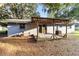 Covered wooden deck with view of the lush backyard and mature trees at 2920 Audie Combee Rd, Lakeland, FL 33801
