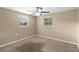 Cozy bedroom featuring neutral walls, carpet, two windows, and ceiling fan at 2920 Audie Combee Rd, Lakeland, FL 33801
