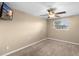 Neutral bedroom featuring a ceiling fan, window, and carpeting at 2920 Audie Combee Rd, Lakeland, FL 33801