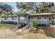 Cozy one-story home with a covered porch, well-maintained lawn, and mature trees providing ample shade at 2920 Audie Combee Rd, Lakeland, FL 33801