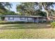 Charming single-story home featuring a covered porch, mature trees, and a well-manicured lawn at 2920 Audie Combee Rd, Lakeland, FL 33801