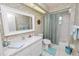 Bathroom featuring a vanity sink, a bathtub with shower, decorative wallpaper, and coordinated accessories at 2936 Grasslands Dr, Lakeland, FL 33803