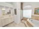 The bathroom is equipped with a soaking tub, vanity, and glass block window, creating a serene atmosphere at 2936 Grasslands Dr, Lakeland, FL 33803
