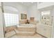 The bathroom features a large soaking tub with tile surround, complemented by a vanity with a mirror and tile floors at 2936 Grasslands Dr, Lakeland, FL 33803