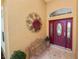 Close-up of the front door featuring decorative wreath and bench on the tiled porch at 2936 Grasslands Dr, Lakeland, FL 33803