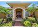 Inviting front entrance with covered porch, decorative columns, and lush landscaping at 2936 Grasslands Dr, Lakeland, FL 33803