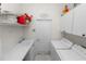 Bright laundry room features a utility sink, open shelving, white cabinets, and a modern washer and dryer at 2936 Grasslands Dr, Lakeland, FL 33803