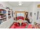 Cozy living room featuring a large bookcase and a comfortable seating area with red rugs and floral decorations at 2936 Grasslands Dr, Lakeland, FL 33803