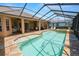 A screened-in pool features a spa, expansive deck, and lovely backyard views, creating an ideal space for relaxation at 2936 Grasslands Dr, Lakeland, FL 33803