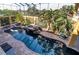 Aerial view of the outdoor pool, hot tub, and rock features surrounded by lush greenery at 3020 Crews Lake Dr, Lakeland, FL 33813