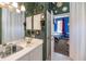 The bathroom features a mirror-covered wall and vanity, with a view into a blue bedroom at 3020 Crews Lake Dr, Lakeland, FL 33813